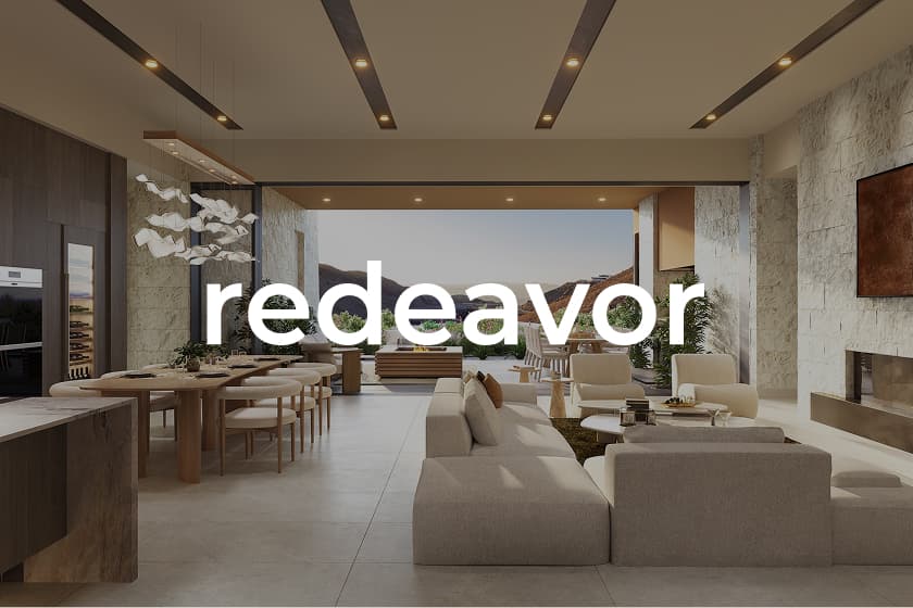 Spacious modern open-plan living and dining area with neutral toned sofas and chairs, a long wood dining table with chairs, a sculptural light fixture over the table, large glass doors opening to an outdoor terrace with mountains in the distance, and the word ‘redeavor’ overlaid in white text.